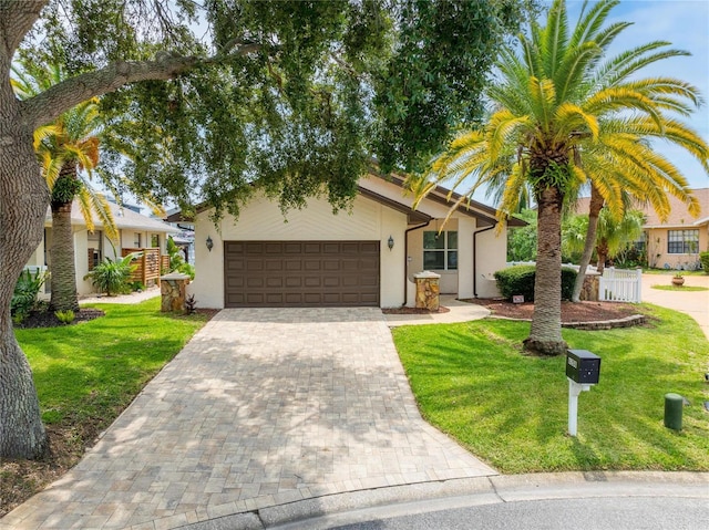 view of front of home with a garage and a front lawn