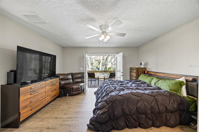 bedroom featuring ceiling fan, access to exterior, light wood-type flooring, and a textured ceiling