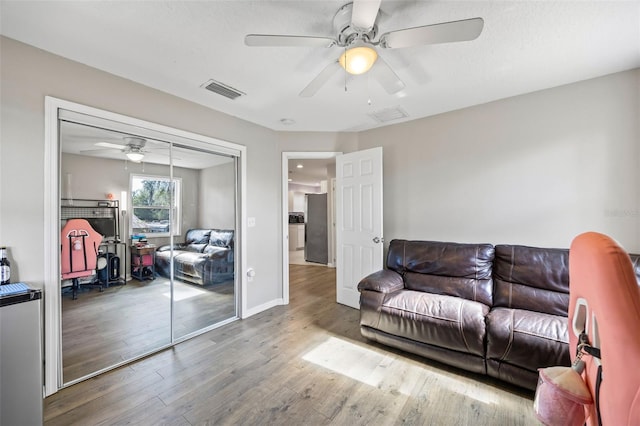 living room featuring hardwood / wood-style floors and ceiling fan