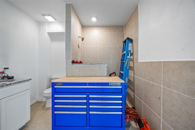 bathroom with walk in shower, tile patterned flooring, toilet, vanity, and tile walls