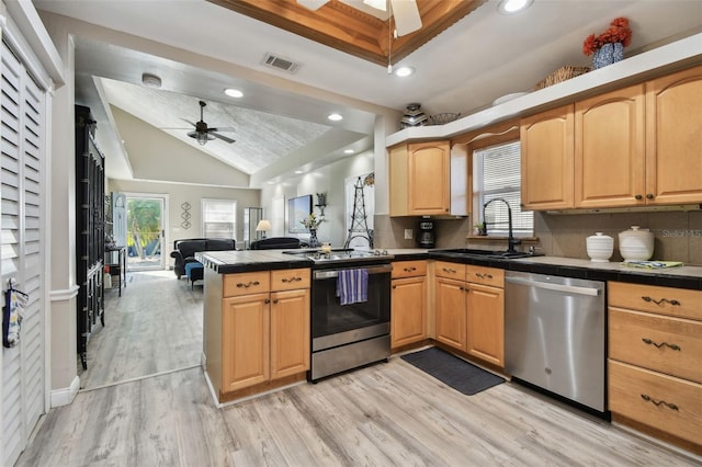 kitchen with sink, backsplash, lofted ceiling, appliances with stainless steel finishes, and light wood-type flooring