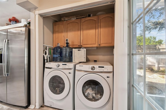 washroom with washer and dryer and cabinets