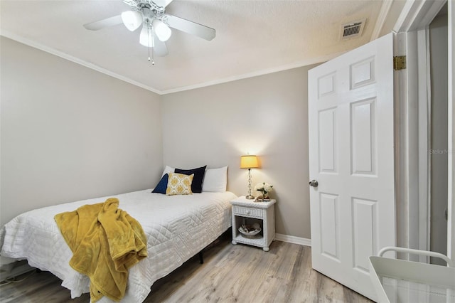 bedroom with light hardwood / wood-style flooring, ceiling fan, and crown molding