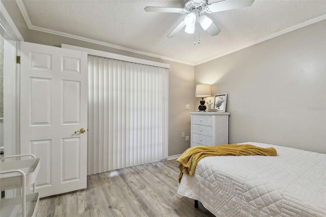 bedroom featuring ceiling fan, ornamental molding, a textured ceiling, and light wood-type flooring