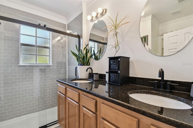 bathroom with vanity, a shower with shower door, and crown molding