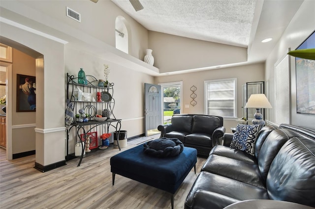 living room with hardwood / wood-style floors, ceiling fan, and a textured ceiling