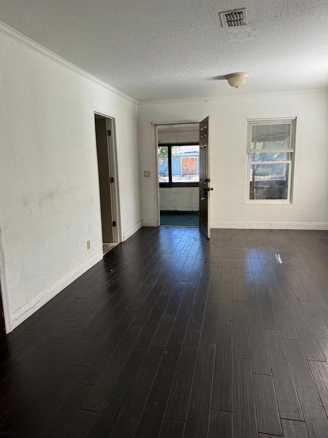 unfurnished room featuring crown molding, dark wood-type flooring, and a textured ceiling