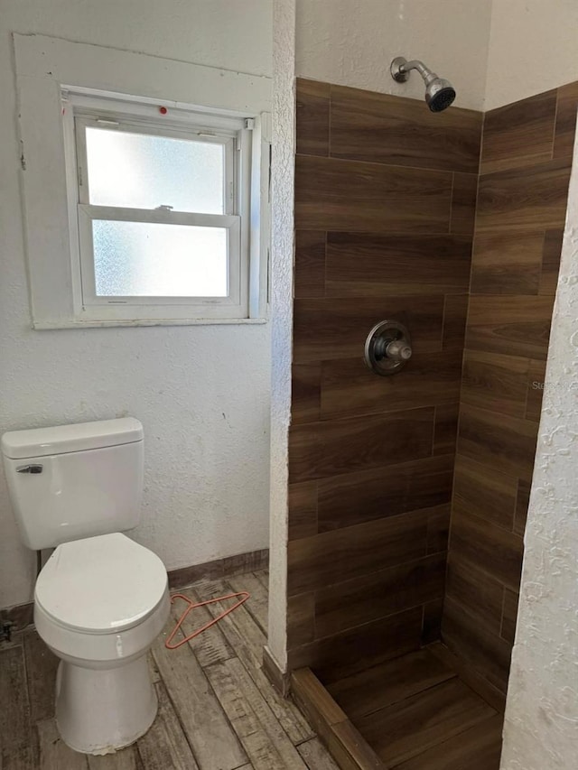 bathroom with tiled shower and toilet