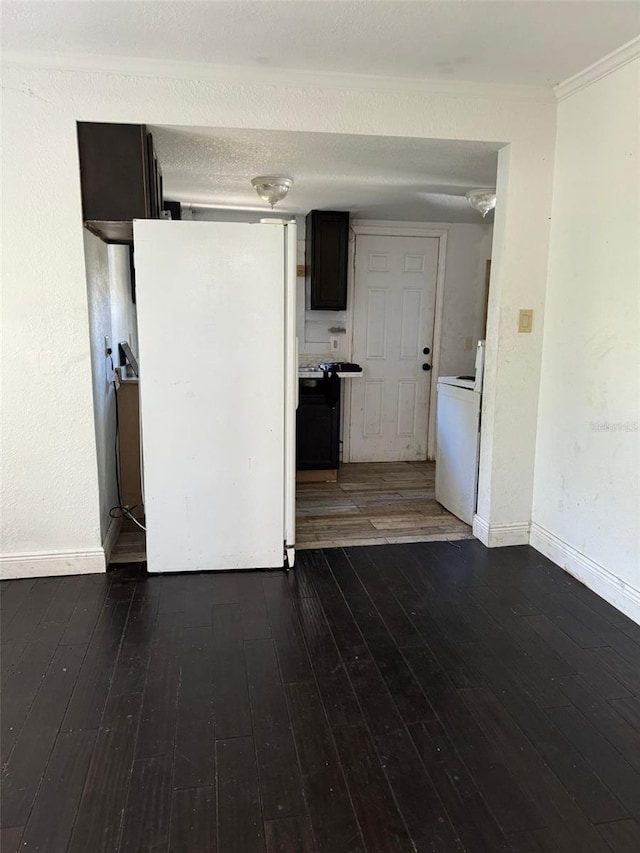 interior space with crown molding, dark hardwood / wood-style flooring, white fridge, and washer / dryer