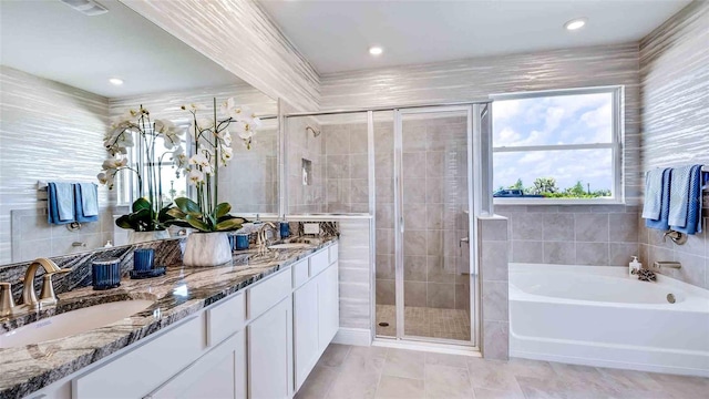 bathroom with vanity, separate shower and tub, and tile walls