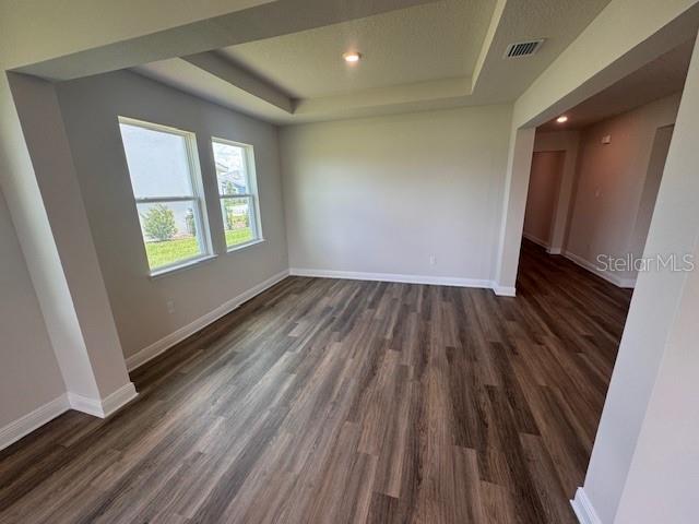 4314 Pullet Ct, Lakewood Ranch, FL 34211 - unfurnished room with a raised ceiling, dark wood-style floors, and recessed lighting