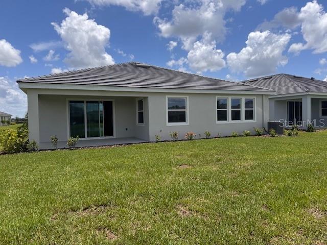4314 Pullet Ct, Lakewood Ranch, FL 34211 - back of property with a lawn, stucco siding, and a patio area