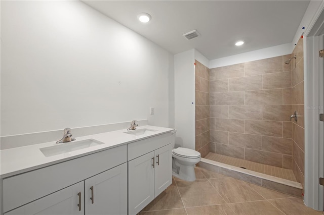 bathroom with a tile shower, tile patterned floors, vanity, and toilet