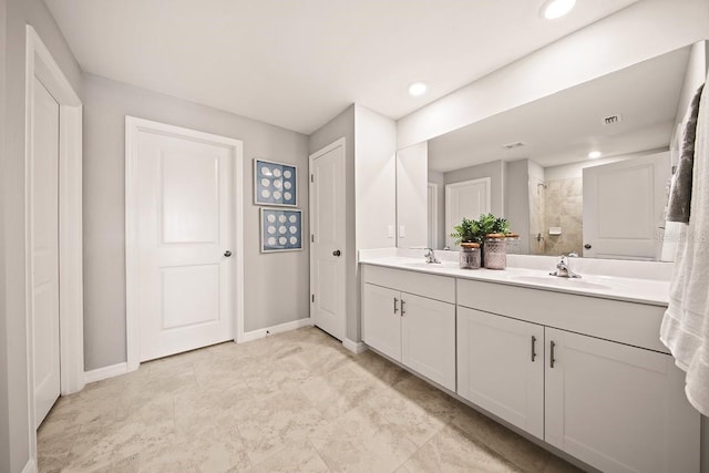 bathroom featuring a tile shower and vanity