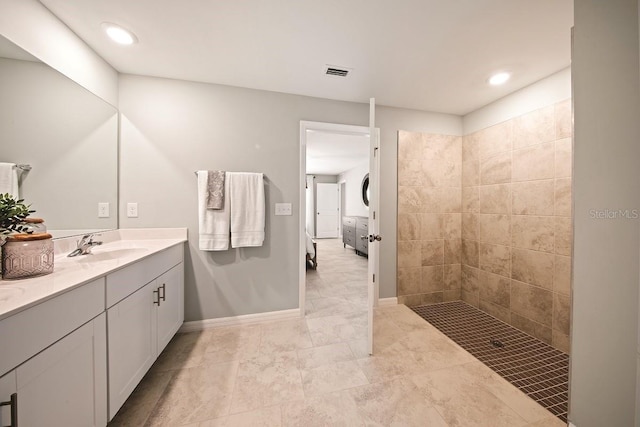 bathroom with vanity and a tile shower