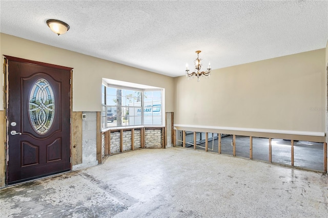 entrance foyer with a chandelier and a textured ceiling