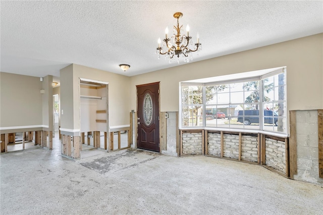 entrance foyer with a textured ceiling and a chandelier