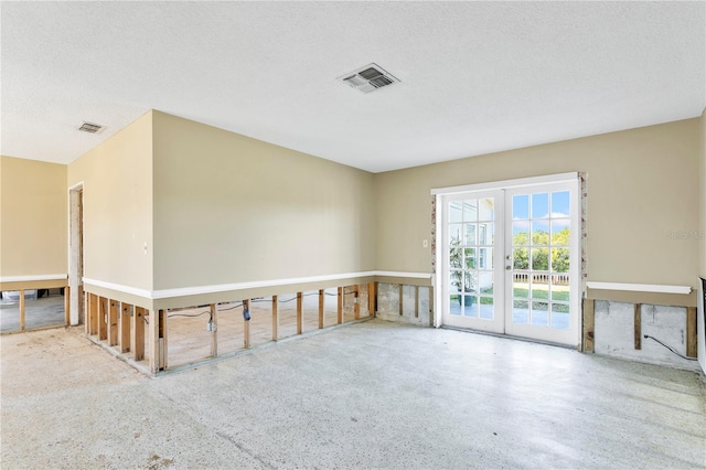 spare room featuring french doors and a textured ceiling