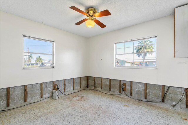 unfurnished room with a textured ceiling and ceiling fan