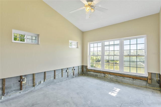 unfurnished room with ceiling fan, plenty of natural light, concrete floors, and vaulted ceiling