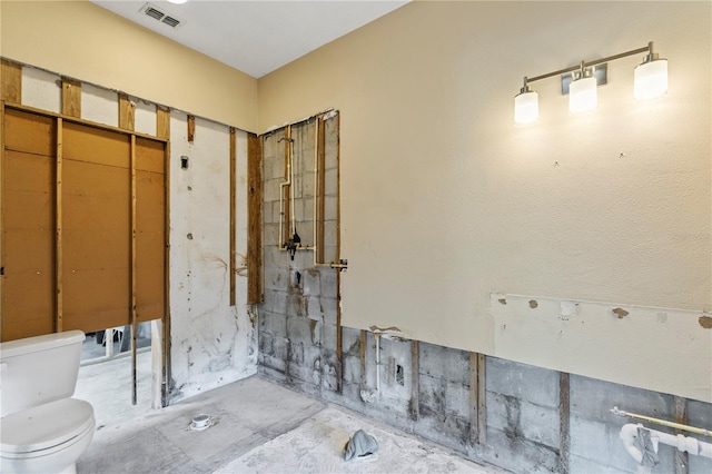 bathroom with toilet and concrete flooring