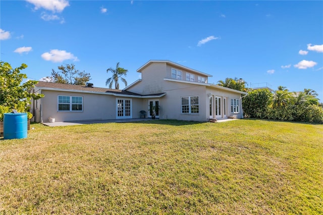 back of property with a yard and french doors