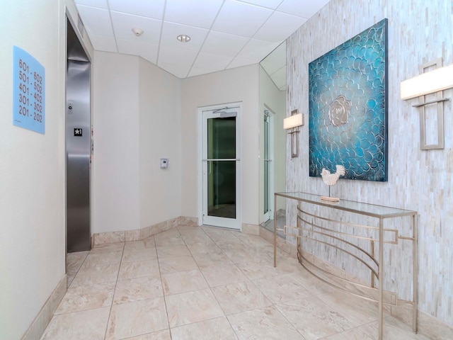 hallway with a paneled ceiling