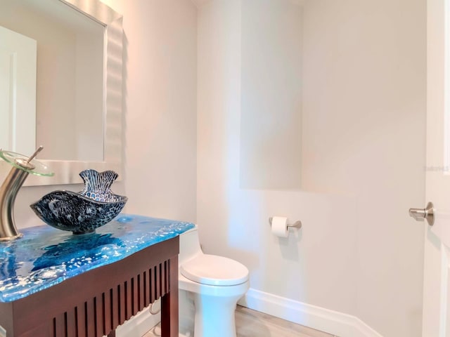 bathroom with vanity, toilet, and wood-type flooring