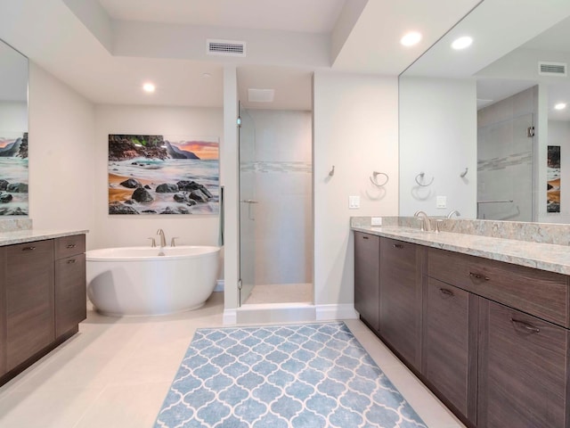 bathroom with tile patterned floors, vanity, and plus walk in shower