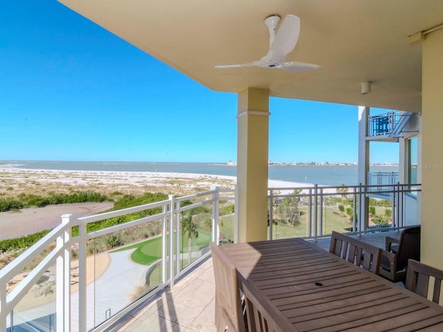 balcony featuring ceiling fan, a water view, and a beach view