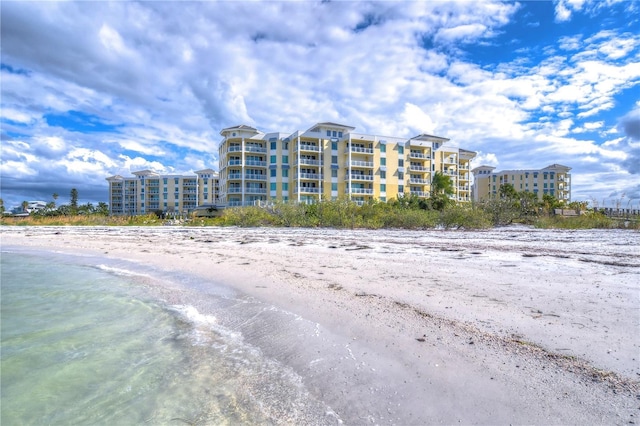 view of building exterior with a water view and a view of the beach