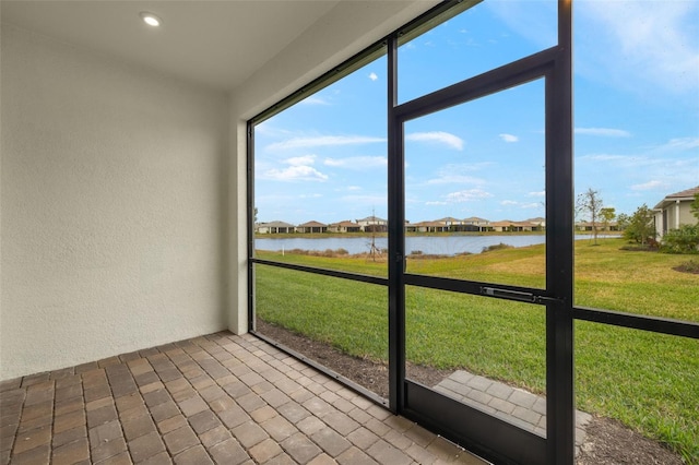 unfurnished sunroom featuring a water view