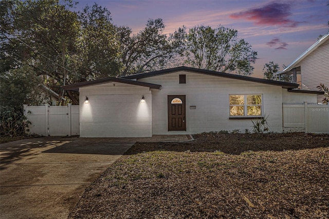 view of front facade featuring concrete block siding, a gate, and fence