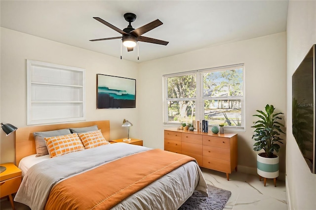 bedroom with marble finish floor and ceiling fan