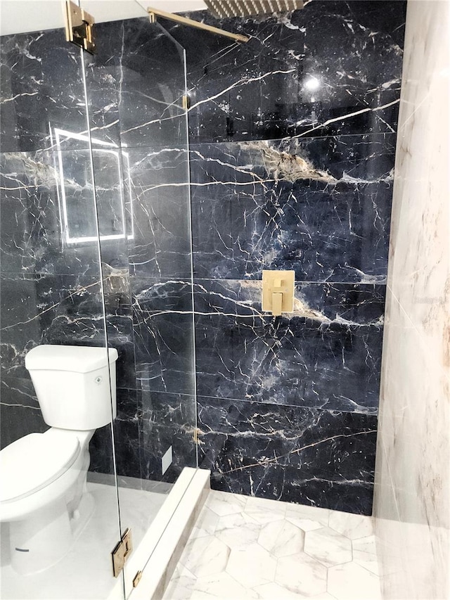 full bath featuring marble finish floor, a stall shower, and toilet