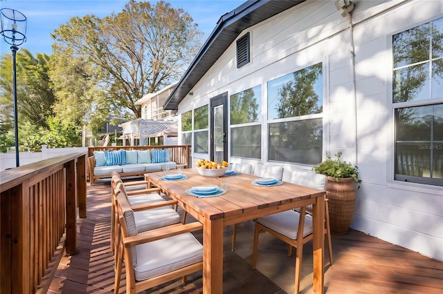 wooden terrace with an outdoor hangout area and outdoor dining area