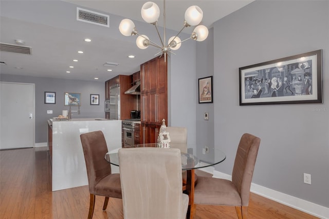 dining room featuring light wood-type flooring and a chandelier