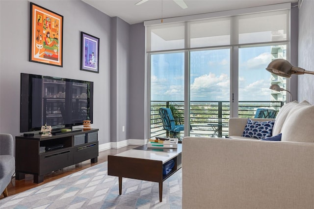 living room with light wood-type flooring, floor to ceiling windows, and ceiling fan