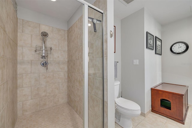 bathroom with tiled shower, tile patterned floors, and toilet