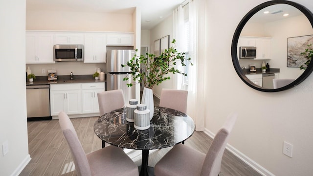 dining area with sink and light hardwood / wood-style flooring