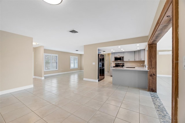 unfurnished living room with light tile patterned flooring and sink