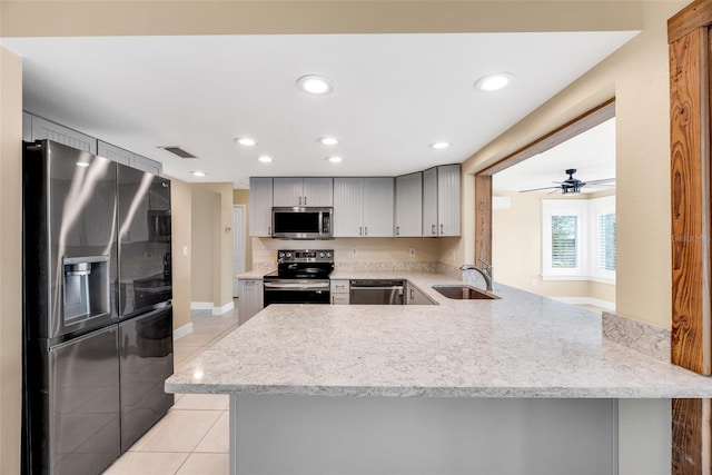 kitchen with kitchen peninsula, sink, light tile patterned floors, and appliances with stainless steel finishes