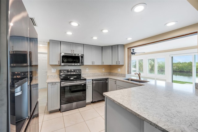 kitchen with light tile patterned floors, stainless steel appliances, gray cabinets, and sink