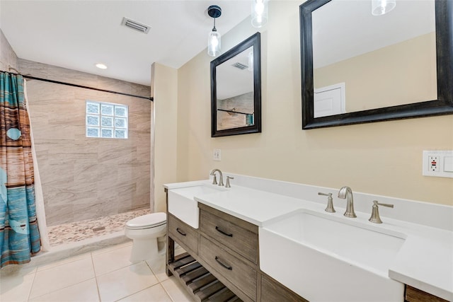 bathroom featuring tile patterned flooring, vanity, toilet, and curtained shower