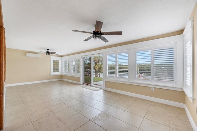 spare room with ceiling fan, light tile patterned flooring, and an AC wall unit