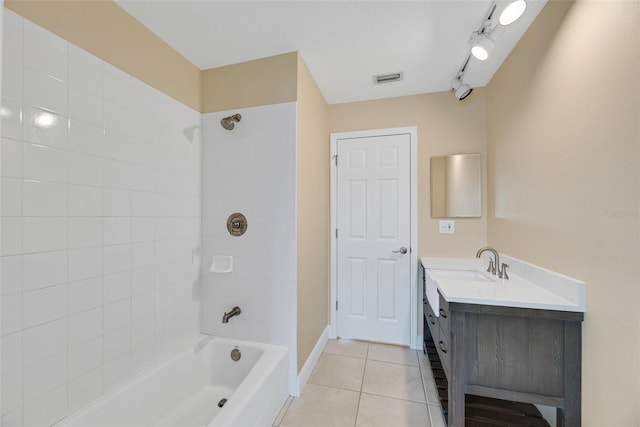 bathroom with tile patterned flooring, vanity, and tiled shower / bath