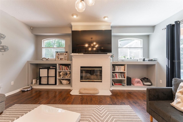 living room featuring dark hardwood / wood-style floors and a tiled fireplace