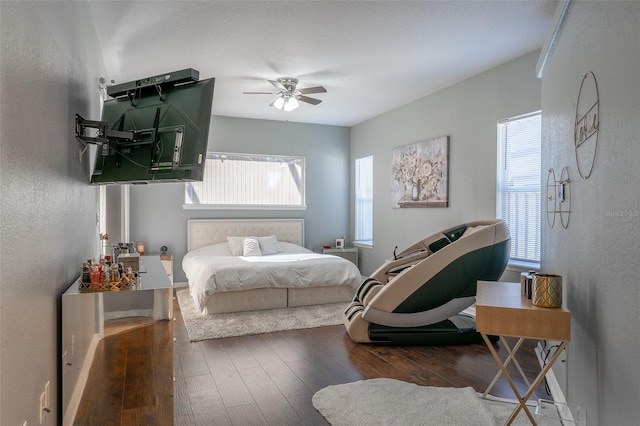 bedroom featuring multiple windows, dark hardwood / wood-style flooring, and ceiling fan