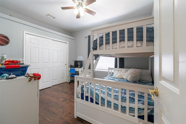 bedroom with a closet, ceiling fan, and dark wood-type flooring