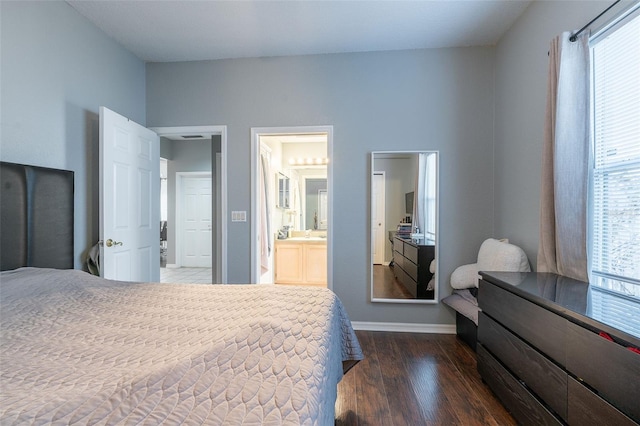 bedroom featuring connected bathroom and dark wood-type flooring